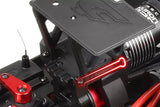 Close-up of a red highlighted Team Corally C-00180-305 Steel Center Roll Cage Pin (2) installed on a black radio control car chassis showing detailed metal and plastic components.