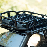Close-up of a black Gmade GM40080 1/10 Scale Off-road Roof Rack & Accessories mounted on an RC car roof, designed for securing gear during off-road adventures.