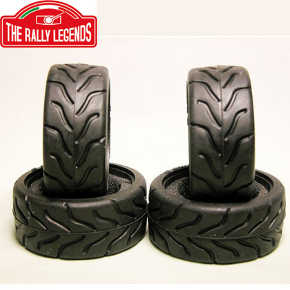 Four black rubber treaded tires designed for radio control cars, displayed in a set with two standing upright and two lying flat, The Rally Legends SPEEDGRIP Tires RC Car Racing (4)