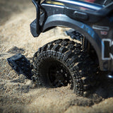 Close-up of a radio control off-road vehicle tire stuck in sand, showcasing rugged tread designed for extreme terrain with Gmade GM40080 1/10 Scale Off-road Roof Rack & Accessories.