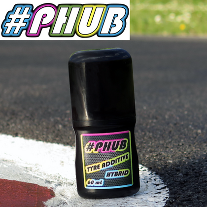 PHUB Hybrid Grip RC Tire Additive Prep Asphalt/High Temp bottle placed on an asphalt surface near a white and red painted track line, designed for radio control car performance.